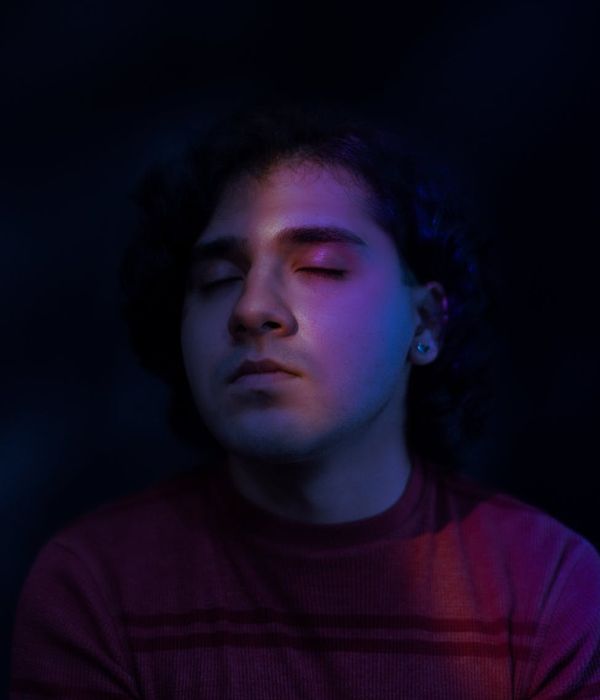 A serene woman focusing on her inner peace in a dark studio